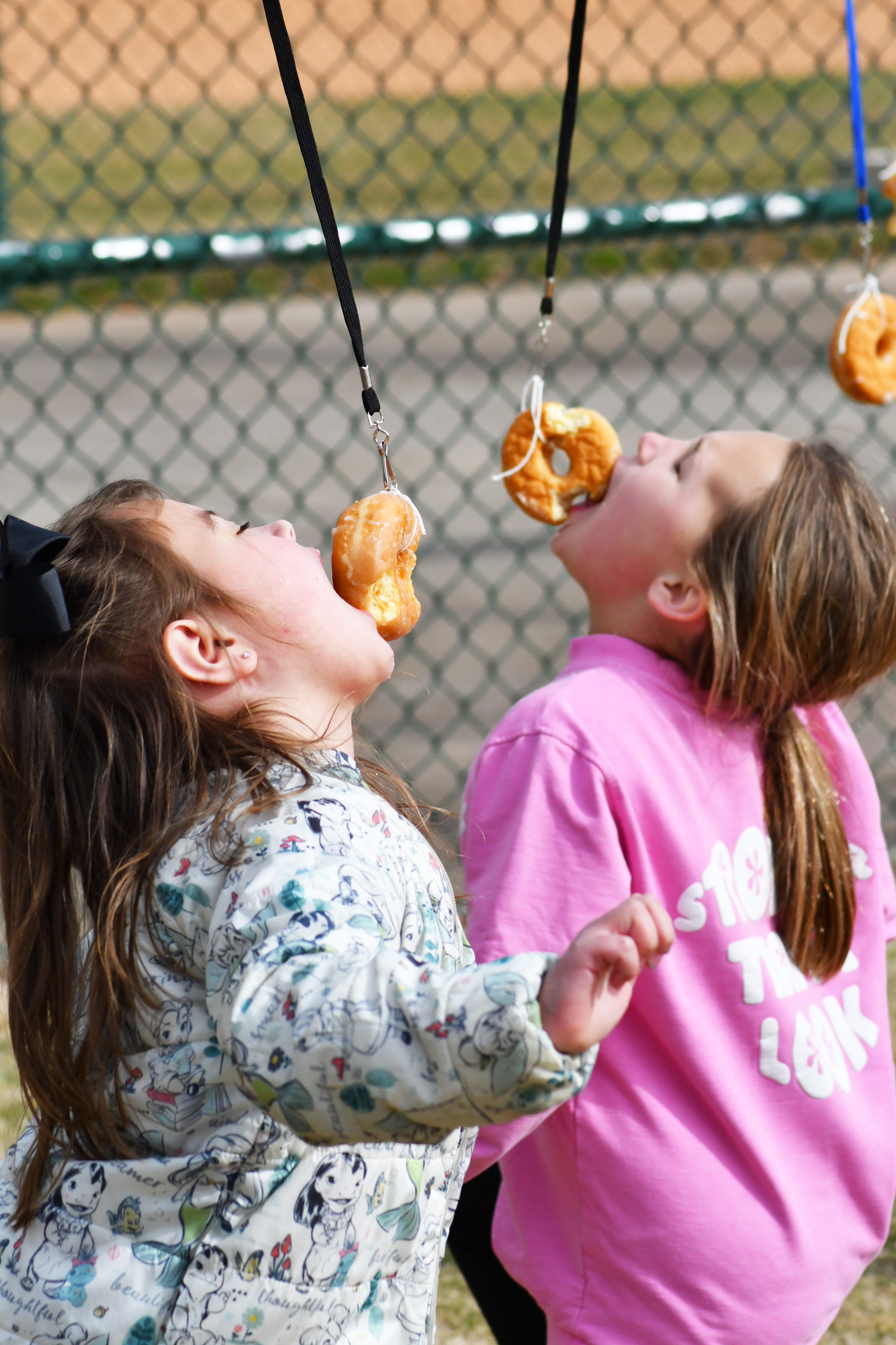 Enoch Autry/The Clayton Tribune.  Delaney Lewis, 6, and Rilye Phillips, 10, participate in a doughnut eating contest at the annual event. 