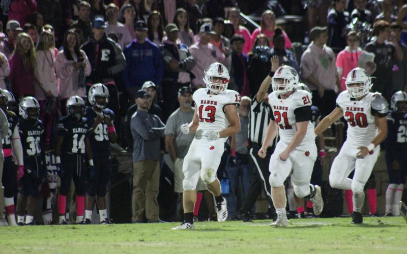Rabun County linebacker Brody Jarrard (13), defensive lineman Phillip Roberson (21) and linebacker Hoff Windham celebrate after Jarrard’s tackle for a loss during the first half against Elbert County at the Granite Bowl in Elberton last Friday night. (Glendon Poe/The Clayton Tribune)