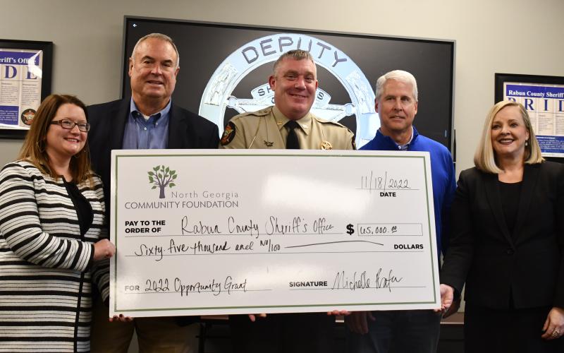 Megan Broome/The Clayton Tribune. Rabun County Commissioner Kent Woerner, Sheriff Chad Nichols and Rep. Stan Gunter are presented with the 2022 Opportunity Grant from the North Georgia Community Foundation by Abigail Carter, director of strategic initiatives for the North Georgia Community Foundation, and Michelle Prater, president and CEO of the North Georgia Community Foundation. The $65,000 check was presented at the Rabun County Sheriff’s Office Nov. 18. 