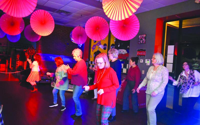 Megan Broome/The Clayton Tribune. Attendees enjoy line dancing with Sharon Williams to music by DJ Hal Rhoad who was spinning tunes.