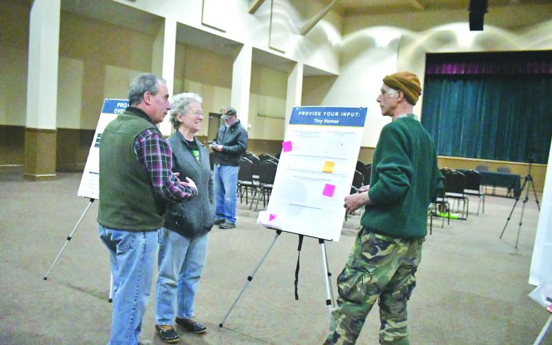 Megan Broome/The Clayton Tribune. Community members Joel Daniel and Frances Daniel (left) point to questions on the bulletin board and converse with Paul Vonk about what they want for the future of zoning.