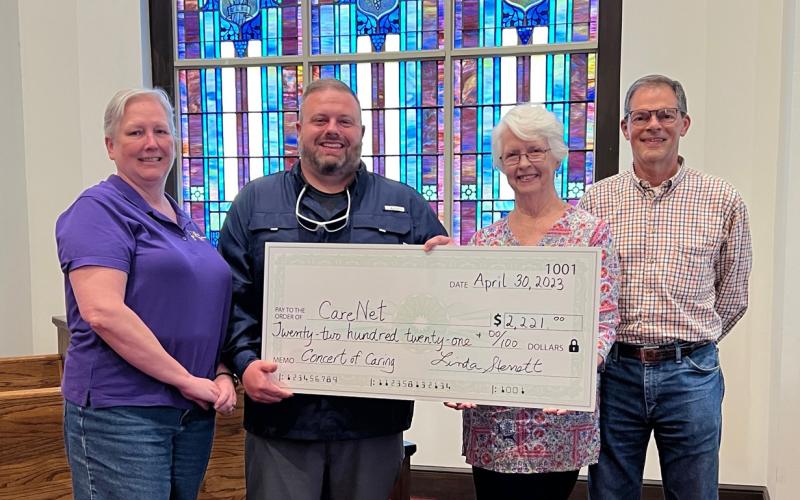 Submitted photo. Linda Sterrett, Brasstown Ringers director, presents a check to CareNet for $2,221 from donations at the concert on April 30, 2023, at First UMC Franklin. Pictured are Linda Sterrett, Brasstown Ringers Director; Tim Hogsed, CareNet Director; Beverly Barnett, Mountain Voices Director; and Vic Greene, CareNet Board Member & First UMC Franklin Pastoral Care. 