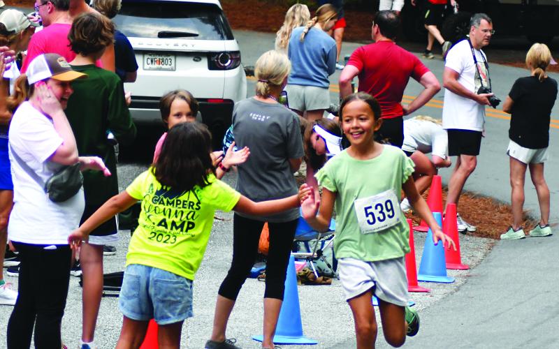 Enoch Autry/The Clayton Tribune. Gabina Cruz, 10, receives congratulations for finishing up her 5K strong at the annual Rabun Ramble on July 1 in Lakemont.
