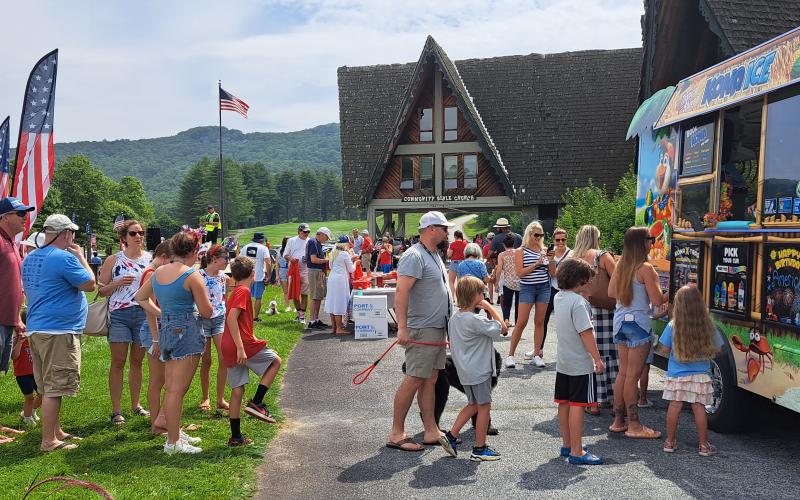 Megan Broome/The Clayton Tribune. Visitors to Sky Valley for Independence Day festivities July 3 stand in line for Kona Ice on the hot day.