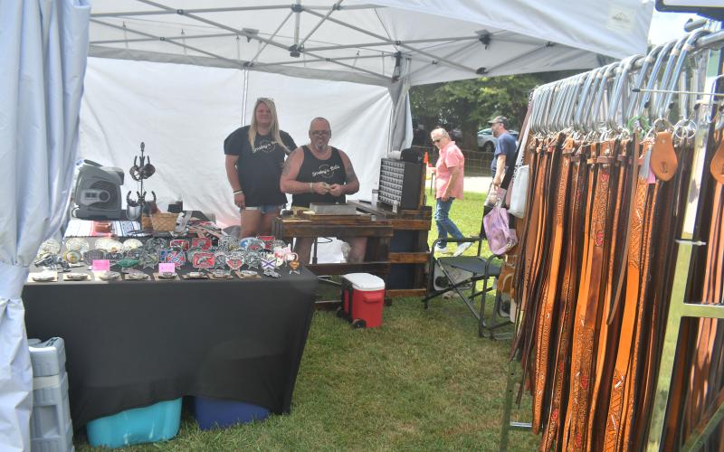 Megan Broome/The Clayton Tribune. Joe and Trina Shipp, owners of the business Smokey’s Belts which creates personalized and hand-stamped products, display their work during the 26th Dillard Bluegrass festival Aug. 4 and 5. 