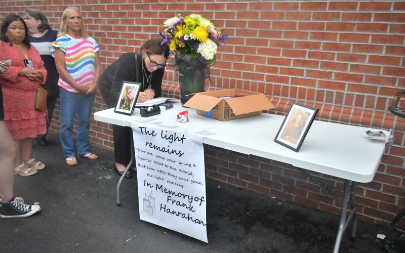 Megan Broome/The Clayton Tribune. Those who knew Hanrahan well signed a guest book sharing stories of how Hanrahan impacted their lives in a positive way on a daily basis during the Candlelight Vigil honoring his life. The table with flowers and pictures of Hanrahan had a sign that read, “The light remains: There are some who bring a light so great to the world, that even after they have gone, the light remains. In Memory of Frank Hanrahan.”