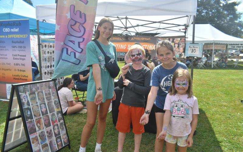 Megan Broome/The Clayton Tribune. Iris Hanson, 14; Freya Hanson, 12; Otis Hanson, 10; and Myrtle Hanson, 6 have their faces painted and get Henna body art and glitter tattoos by Kristina Robak with her business Face Painting by Kristina. 