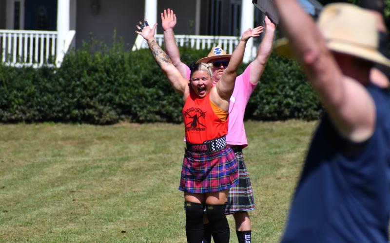 Wade Cheek/The Clayton Tribune. Competitors celebrate after a successful caber toss in this year’s North Georgia Highland Games. The Caber Toss is when athletes must flip a tall wooden pole where the goal is to have the pole land in the 12-o’clock position. 
