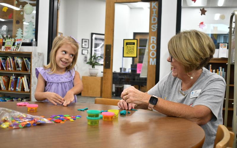 Megan Horn/The Clayton Tribune. Kate Getty, 4, has fun making Play-Doh creations with Kim Cannon, Children’s Services, during the “1,000 Books Before Kindergarten” kickoff event at the Rabun County Public Library Sept. 21. 