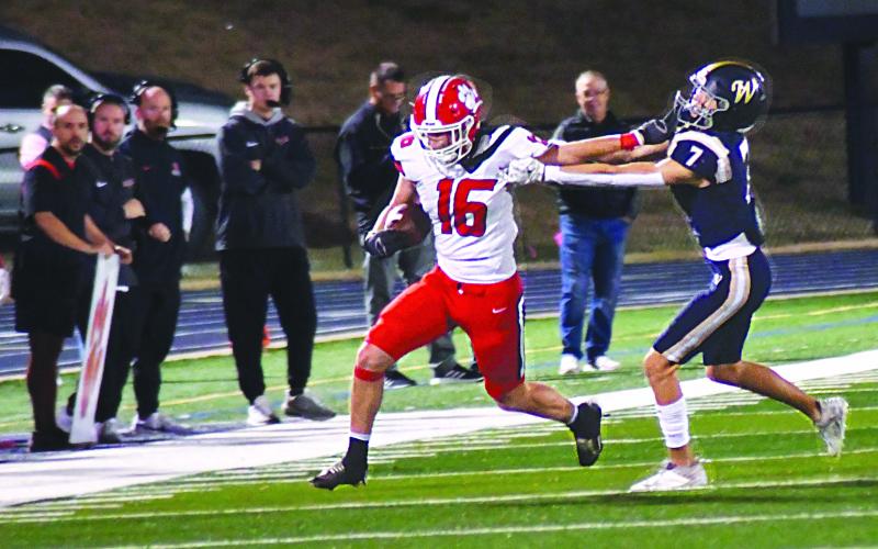 Enoch Autry/The Clayton Tribune. Rabun County senior wide receiver Cooper Welch gives a stiff-arm to Whitefield Academy’s senior free safety Jack Schuster for yards after the catch in the second round of the Class A Division I state playoffs.