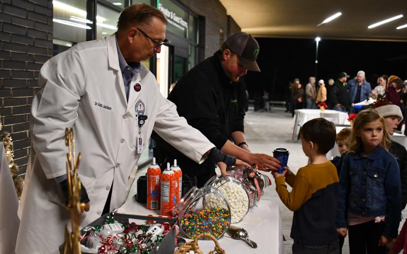 Megan Horn/The Clayton Tribune. Dr. Keith Jackson and Jack Hinkle hand Jayce Ginsberg, 5, a cup of hot chocolate on a cold Dec. 14 evening at Mountain Lakes Medical Center for the meet-and-greet event with Santa. 