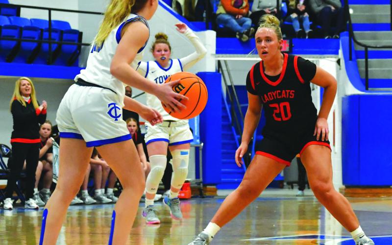 Wade Cheek/The Clayton Tribune. With head coach DeeDee Dillard watching on the left, senior Lady Cat Ellie Southards plays defense against Towns County in December.
