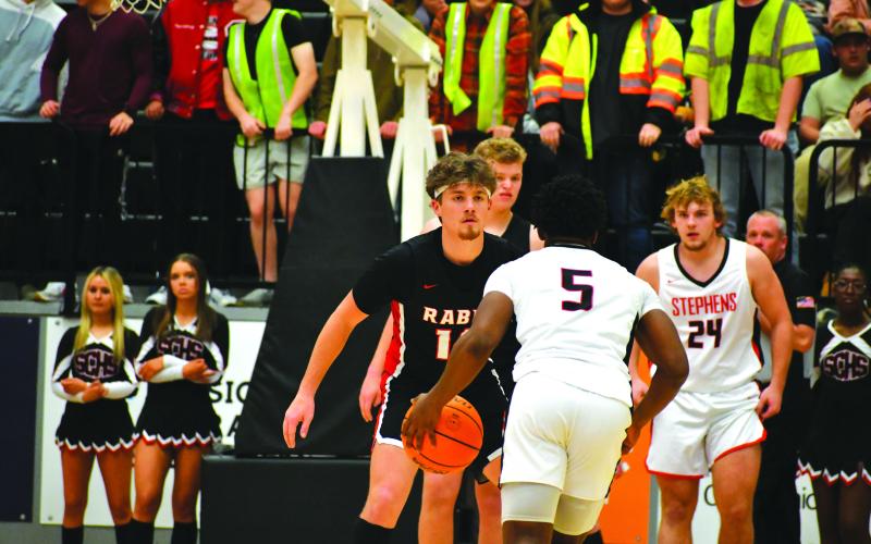 Wade Cheek/The Clayton Tribune.  In front of the Stephens County Indians student section and cheerleaders, Rabun County senior Cooper Welch plays defense with senior Jack Hood and his fellow teammates in Toccoa.
