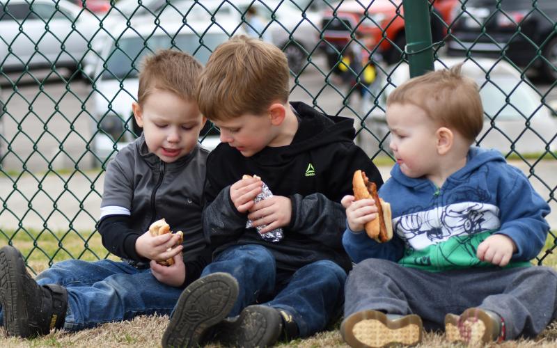 Enoch Autry/The Clayton Tribune. Brothers Desmond Huber, 3; Greyson Solary, 5; and Adam Huber, 2, enjoy a moment while eating hot dogs at the annual event on March 25.