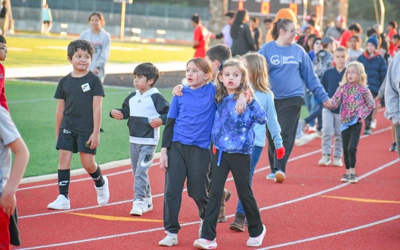 Wade Cheek/The Clayton Tribune. Youth soccer Lady Cats Juliette Pitassi (left) and Reeves Bragg walk arm-in-arm around Frank Snyder Memorial Stadium as part the March 19 “Rec Night” in between the RCHS girls and boys soccer games. 