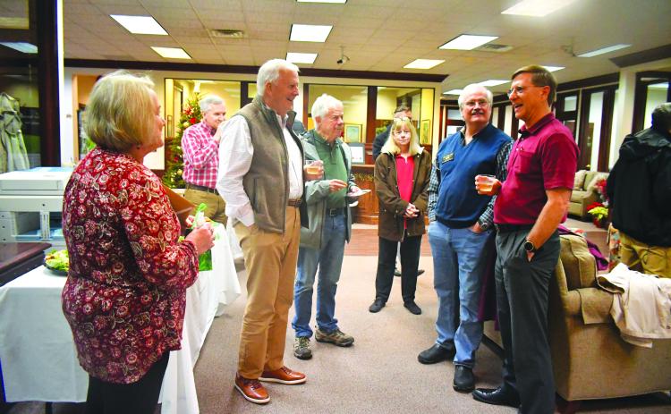 Megan Broome/The Clayton Tribune. Greg Funkhouser (right) and wife Cathee smile and laugh as they meet-and-greet community members at Rabun County Bank Dec. 14 for a retirement reception honoring his 43 years of service at the bank. 