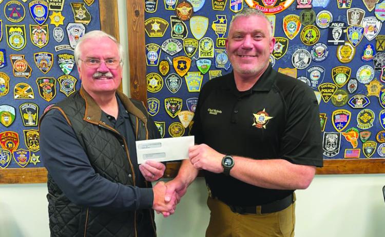 Submitted photo. Rotarian Lee Penland presents a $10,000 grant check from the Clayton Rotary Foundation, Inc. to Rabun County Sheriff Chad Nichols to support the sheriff’s office mental health initiative as it establishes a mental health unit within the office.
