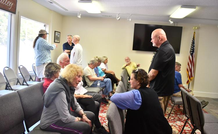Megan Horn/The Clayton Tribune. Sky Valley Chief of Police Vaughn Estes converses with community members at Tuesday’s emergency called council meeting as many people came out to support Estes after he was suddenly terminated Oct. 2.
