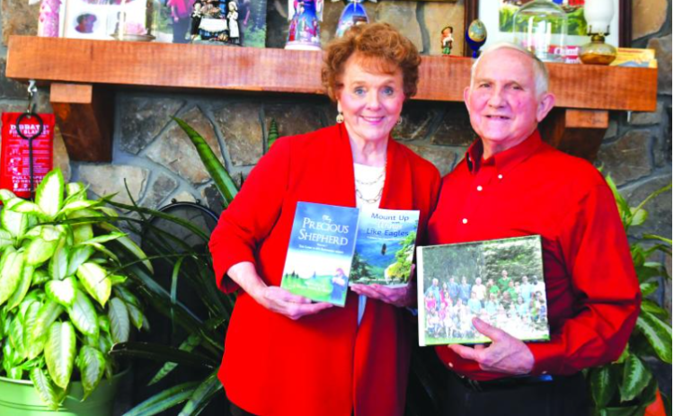 File photo/Megan Horn/The Clayton Tribune. Standing with his wife Marywinn as the two hold books they authored, Dr. George Lent passed away on Feb. 22.