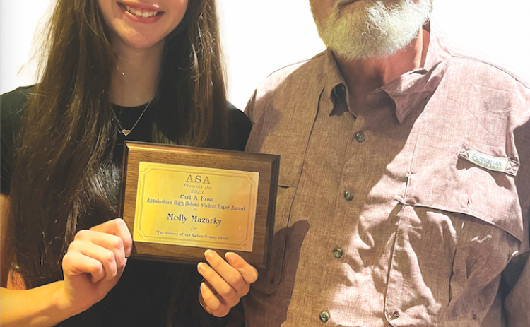Photo submitted. Molly Mazarky holds her award as she stands with her grandfather Lynwood Cash, president of the Rabun County Cross Society.