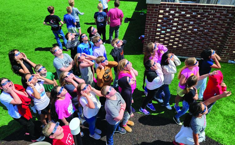 Enoch Autry/The Clayton Tribune. Wearing the eclipse shades, Rabun County Elementary School students gaze toward the sky during Monday’s solar eclipse. Left: Hudson Hamby sees the Eclipse in the sky Monday.