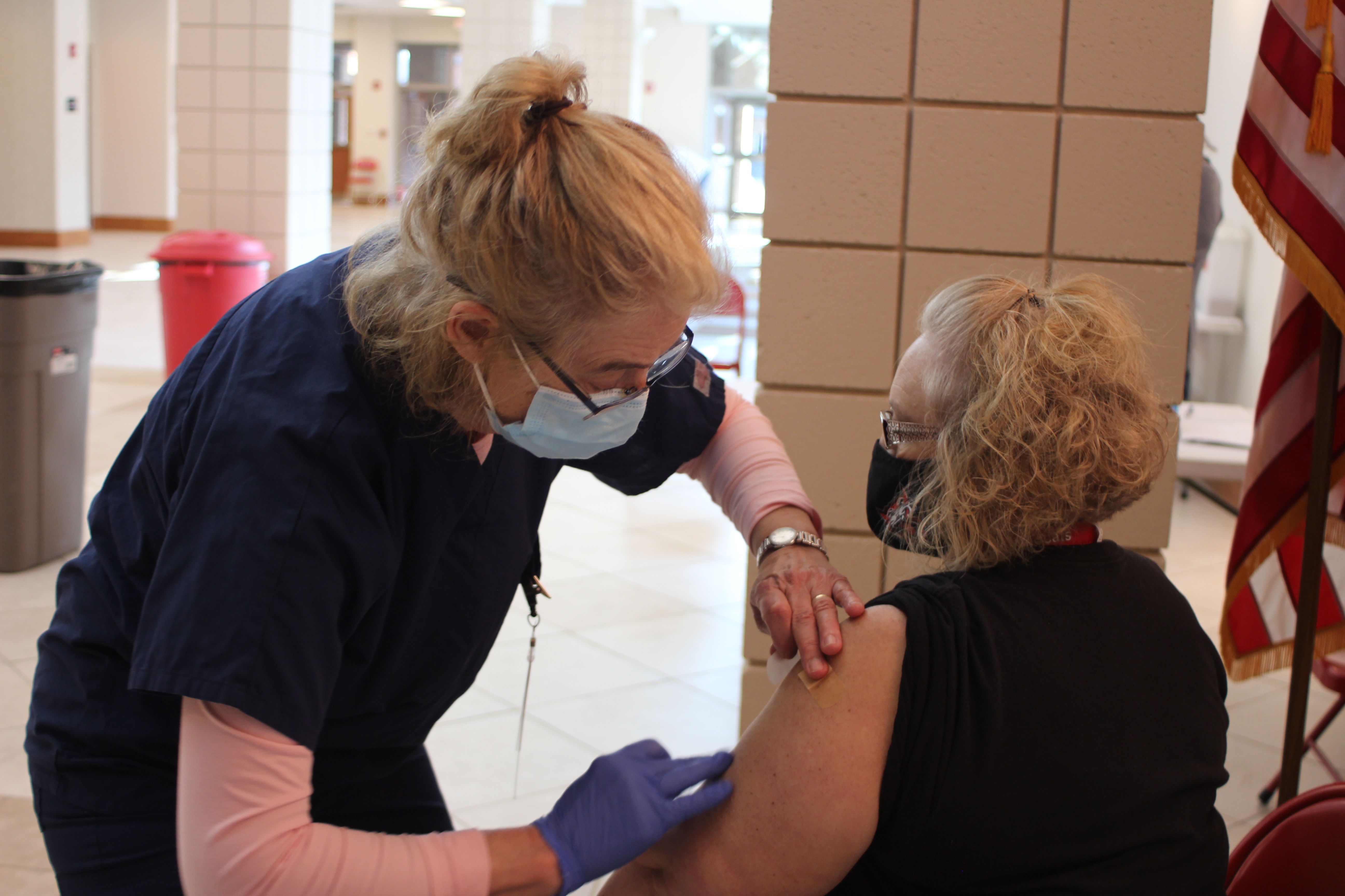 Megan Broome/The Clayton Tribune. Cheryl Crouse, RN at Mountain Lakes Medical Center, administers a Moderna vaccine to Patricia Vaughn, teacher for Wildcat virtual academy at the high school, at last Friday’s vaccine clinic held in the Rabun County Schools Fine Arts Building. 