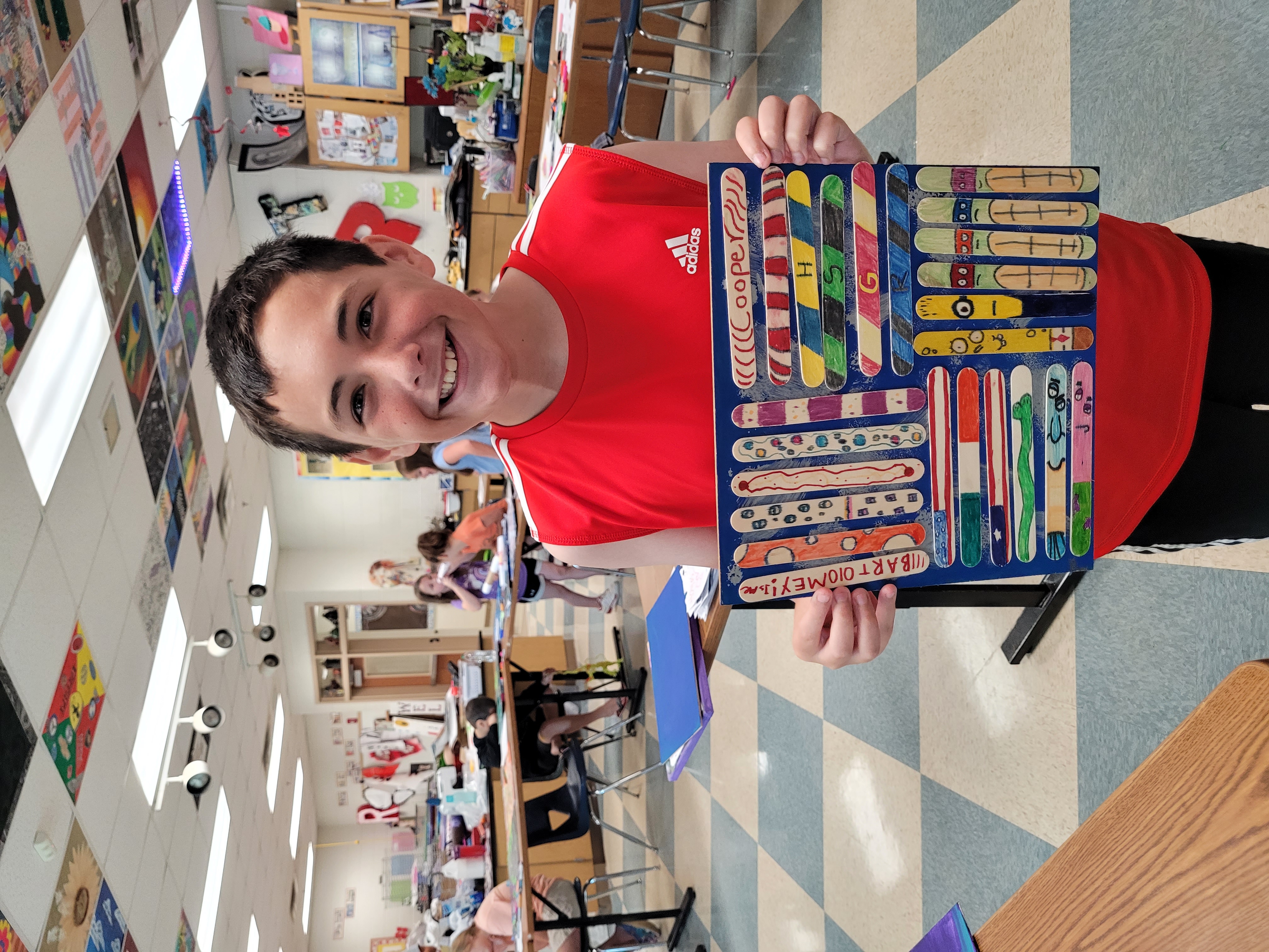 Megan Broome/The Clayton Tribune. Cooper Bartolomey, 11, proudly shows off the art project he made during Art Camp with Mrs. Amy Jarrard last week. Bartolomey’s art project includes some of his favorite characters, such as Minions and Ninja Turtles. 