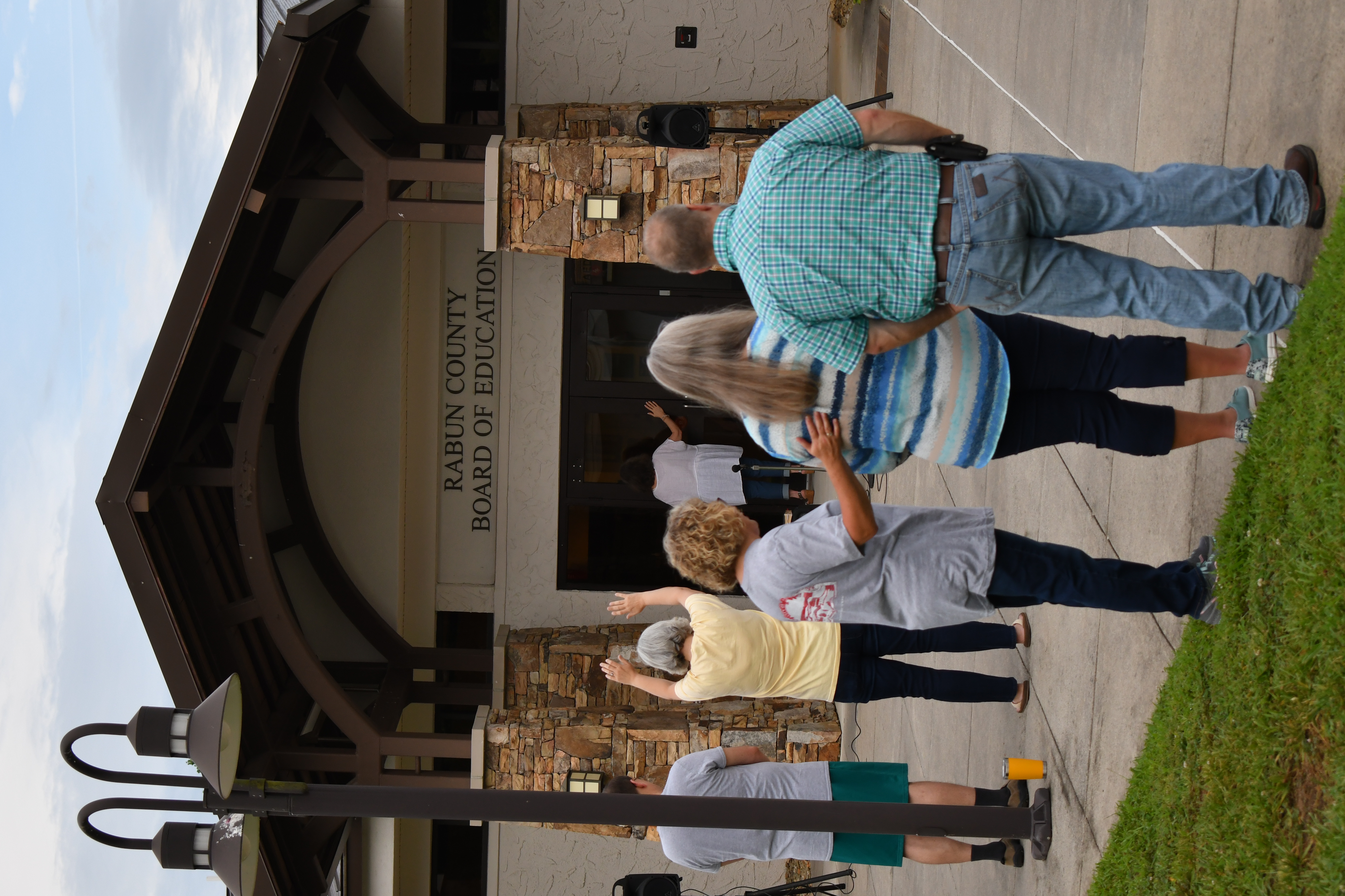 Enoch Autry/The Clayton Tribune. The group prays at the board of education office to start the morning.