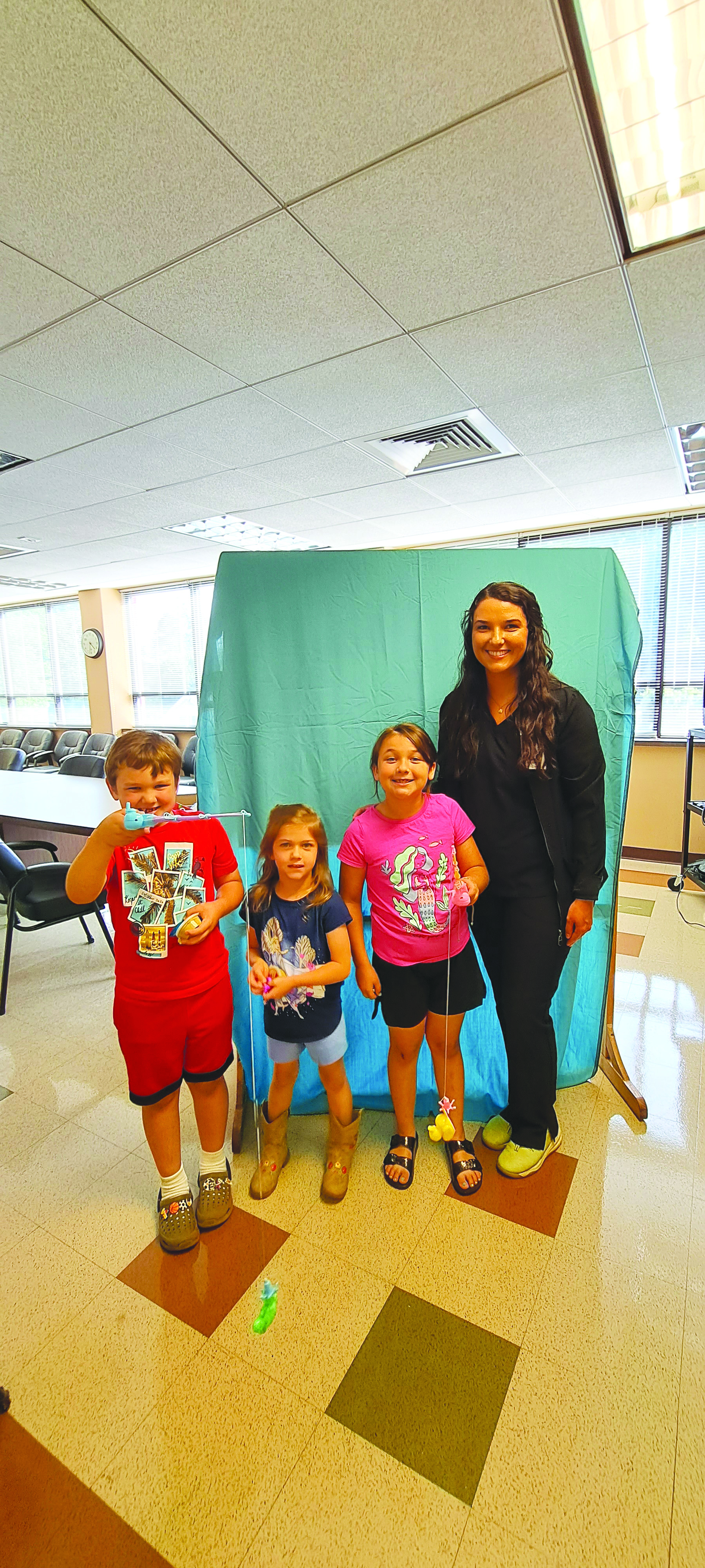 Megan Broome/The Clayton Tribune. Jaxon Webb, 6; Nora Webb, 4; and Marla Webb, 7, enjoy a fishing game with Amber Gragg at the Rabun County Health Department June 6 for the meet and greet event.