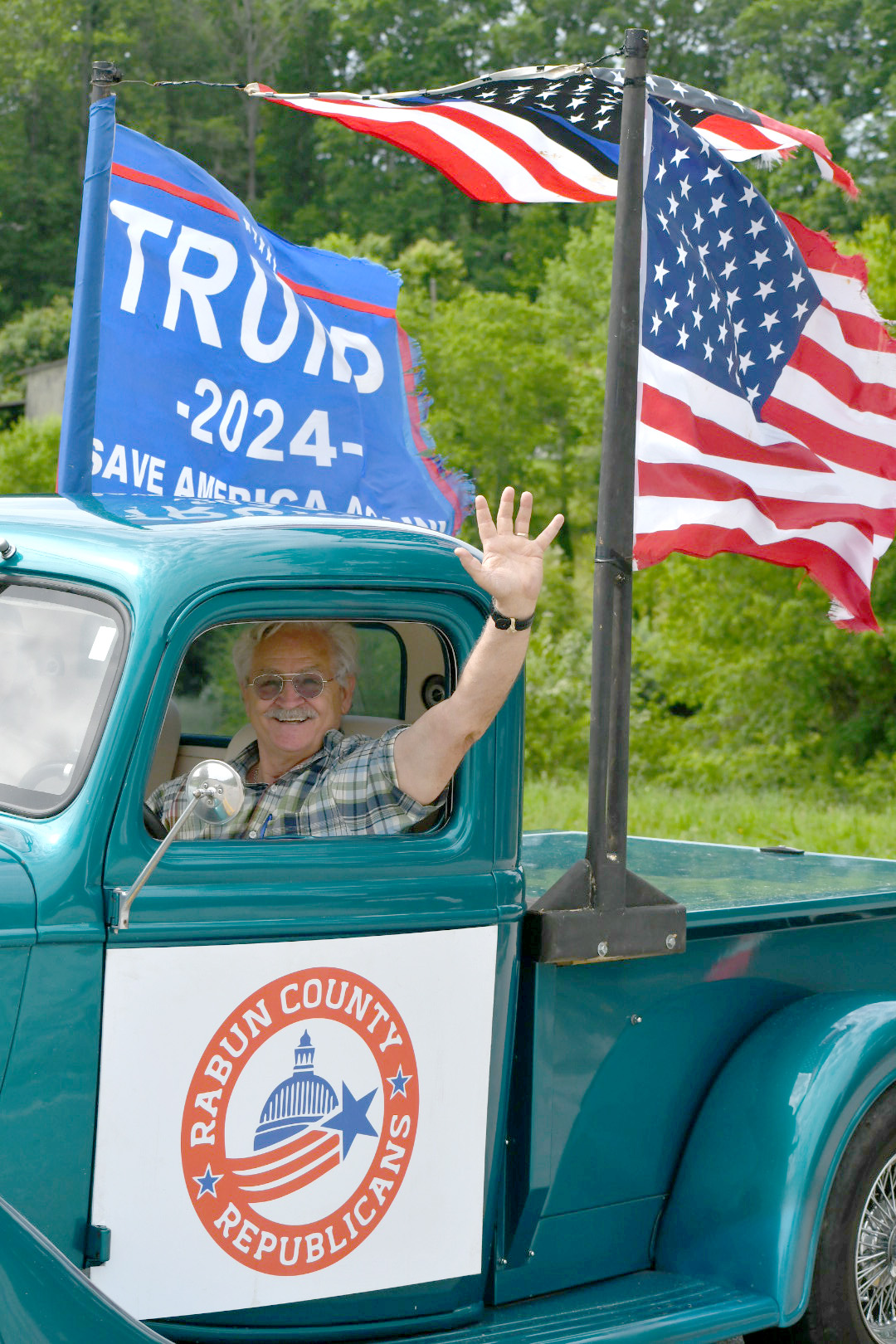 Enoch Autry/The Clayton Tribune. Carl Stokes with the local Republican Party drives his 1937 pickup in the convoy and waves at those lining the roadside in Tiger.