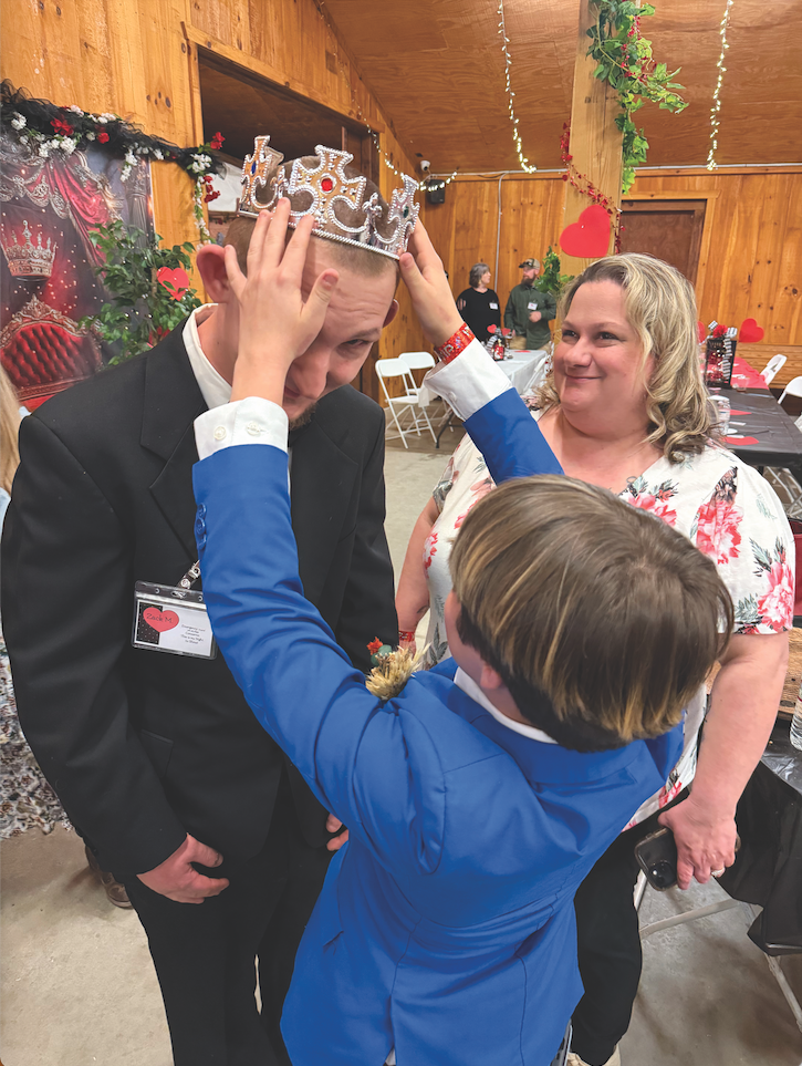 Katie Hamby/The Clayton Tribune. Zack Montgomery receives his crown as “buddy” Carrie Bennett watches.