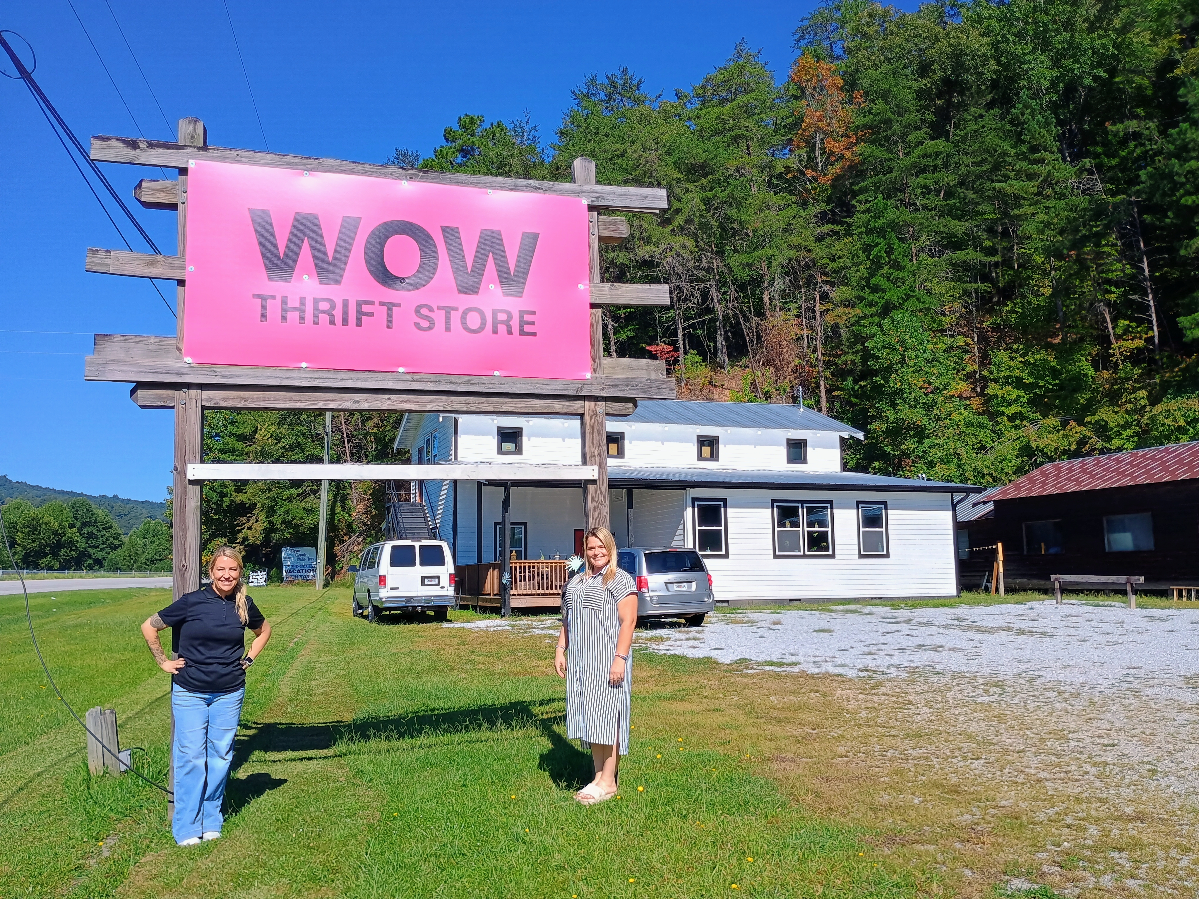 Megan Horn/The Clayton Tribune. WOW Recovery is making a difference in the community by providing resources and a structured program to help women in recovery from addiction. Pictured are WOW Recovery Director Ashley York, left, and Resident Manager Tiffany Young, who is also a Peer Support Specialist for WOW and Rabun County. They stand in front of the new donated sign for the Wow! What a Deal! Thrift Store. 