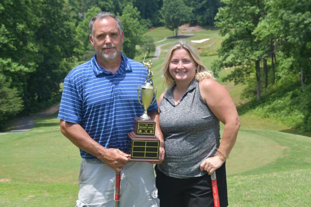 Wesley Branch/The Clayton Tribune. Jamie Smith (right) and Jason Murphy pose with the Wildcat Open trophy after winning the inaugural Wildcat Open Tournament on June 5 at Kingwood Golf Club. Smith and Murphy will have their names and score placed on the trophy, which will be displayed on RCHS’ campus. 