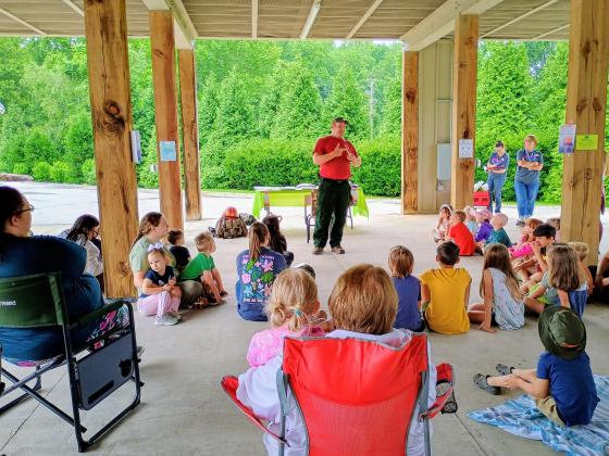Megan Horn/The Clayton Tribune. Wildland Firefighter Thomas with the U.S. Forest Service talks to kids about fire safety and how to prevent forest fires during a Rabun County Public Library summer program event on Tuesday, June 9. 