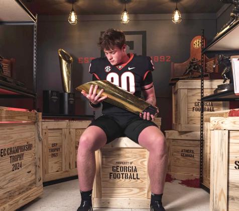 Image via Marcellus_yc on Instagram. Rabun Gap defensive lineman Marcellus Young Casario poses with a national championship trophy during his official visit to Georgia. Casario announced his commitment to the Bulldogs on June 15.  
