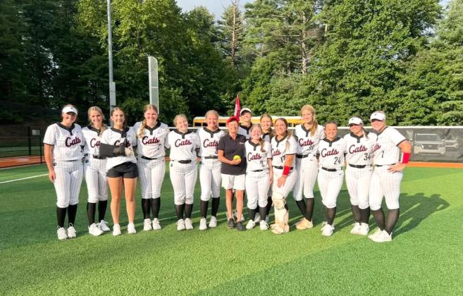 Submitted Photo. Former Rabun County High School teacher and coach Janice Wayne (center) poses with the Rabun County softball team after throwing the first pitch at a game during the 2025 season. Wayne, the first-ever softball coach at RCHS who also assisted athletics in a plethora of ways, passed away on June 24 at the age of 72. 