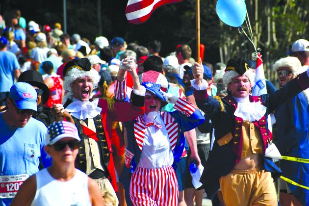 Wesley Branch/The Clayton Tribune. Several participants of the Lake Burton Fun Run showed their patriotism by wearing red, white and blue, or by dressing up in costumes like the trio celebrating here as they cross the finish line. Despite the warm temperatures, thousands were in attendance on July 4 for the 42nd annual Lake Burton Fun Run from Moccasin Creek State Park to LaPrade’s Marina. 