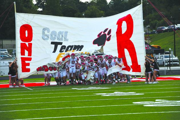 Enoch Autry/The Clayton Tribune. Rabun County football players break through the cheerleaders’ handmade banner on Aug. 14 prior to the Wildcats’ scrimmage on the road against Franklin, N.C. RCHS kicks off its regular season at home on Aug. 28 versus the Tigers of Metter, led by former Wildcat coach and player Lee Shaw. 