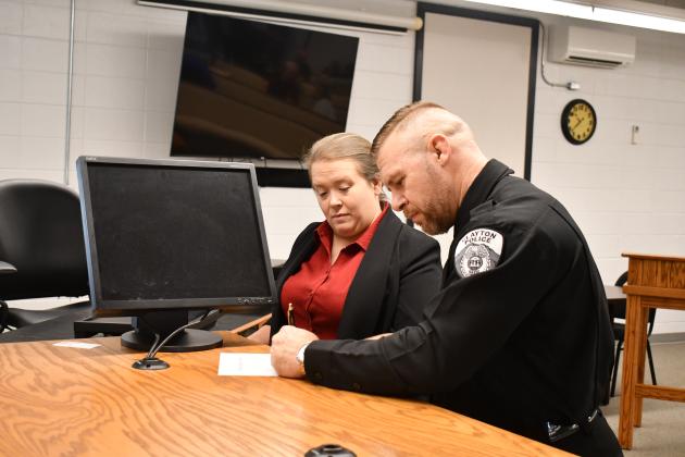 Megan Horn/The Clayton Tribune. Newly sworn-in Clayton Police Chief Kevin Marsteller, right, signs paperwork next to Rabun County Probate Judge Savannah Dixon after administering the Oath of Office to Marsteller on Thursday, Aug. 27, in the courtroom at Clayton City Hall. 