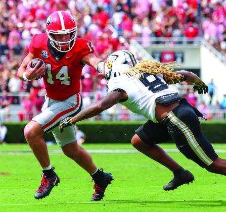 Landen Todd/CNI News Service. Georgia quarterback and Tiger resident Gunner Stockton stiffarms Vandy’s CJ Heard as the senior rushed seven times for 22 yards in Georgia’s SEC win. No. 2-ranked UGA faces No. 6 Alabama on Saturday.