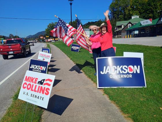 Megan Horn/The Clayton Tribune. Rabun County Republican Party Chair Benita Cotton-Orr and Treasurer Linda Burns encourage citizens to vote during a flag waving event held outside The Rusty Bike Cafe on the first day of early voting, Oct. 13. 