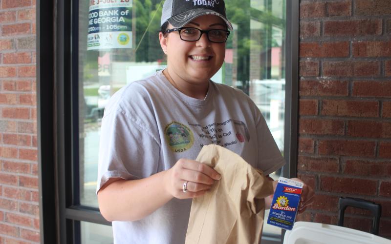 Rabun County Family Connections employee Alora Burt passes out meals to children at the Food Bank of Northeast Georgia in Clayton on Monday as part of the United States Department of Agriculture Summer Food Service Program.