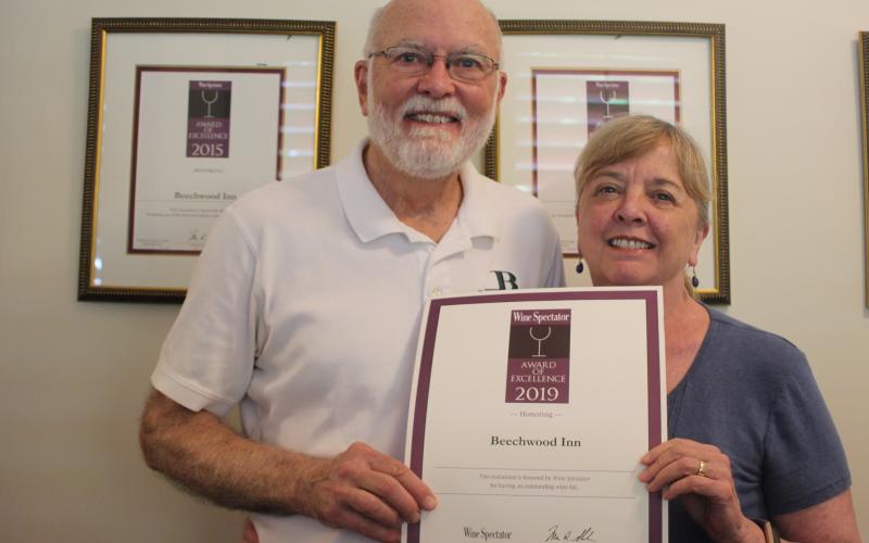 Megan Broome/The Clayton Tribune. David Darugh, left, and Gayle Darugh, hold up their award for having Beechwood Inn honored for its wine program with the Wine Spectator Restaurant Award of Excellence for 2019. They have been a consecutive winner of the award since 2007.