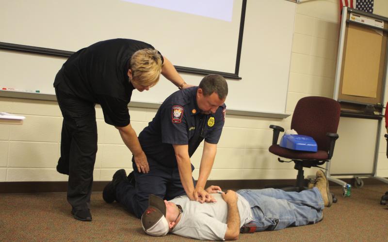 Megan Broome/The Clayton Tribune. Lt. Misty Houston, Rabun County Emergency Services, Justin Upchurch, assistant chief of Rabun County Fire Services and Hunter Hargrave, Rabun County Firefighter, give a lesson on how to administer chest compressions to students in emergency situations at Rabun County School’s annual bus driver training on Thursday, July 25.
