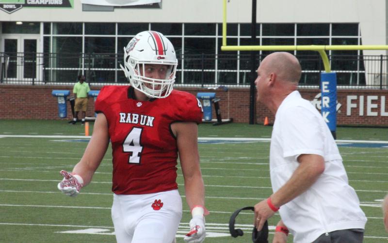 Rabun County cornerback Braxton Hicks (4) talks with defensive coordinator Rob Stockton during a break in first-half action against Bremen in the Erk Russell Classic at Georgia Southern’s Paulson  Stadium in Statesboro last Saturday night. (Glendon Poe/The Clayton Tribune)