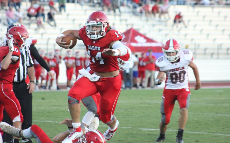 Rabun County quarterback Gunner Stockton (14) leaps a fallen Franklin (N.C.) player during a touchdown run in the second quarter of a preseason game at Frank Snyder Memorial Stadium in Tiger last Friday night. (Glendon Poe/The Clayton Tribune)