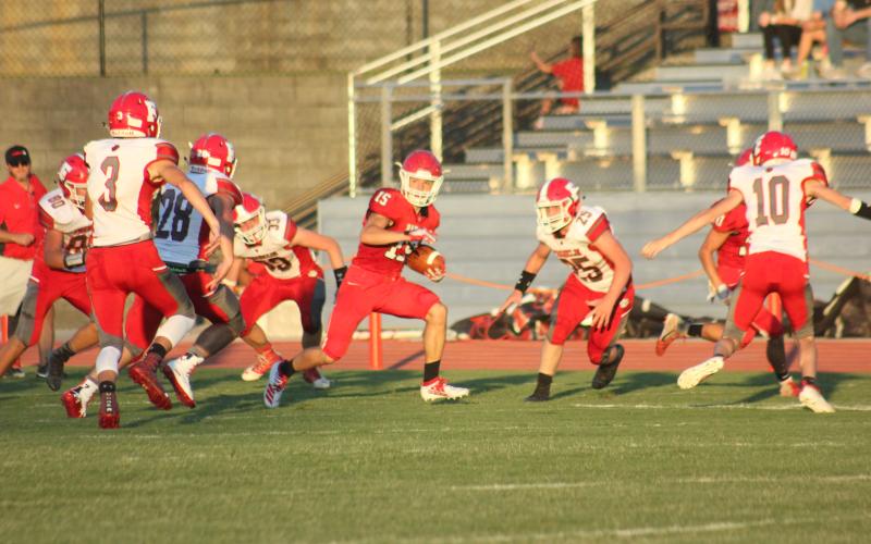 Rabun County wide receiver Sam Adams, middle, looks for  additional yards after making a catch during the first quarter of a preseason game against Franklin (N.C.) at Frank Snyder Memorial Stadium in Tiger last Friday night. (Glendon Poe/The Clayton Tribune)