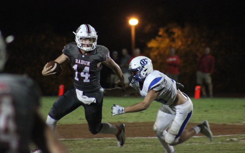 Rabun County quarterback Gunner Stockton (14) runs from a Banks County defender during the second half at Frank Snyder Memorial Stadium in Tiger last Friday night. (Glendon Poe/The Clayton Tribune)