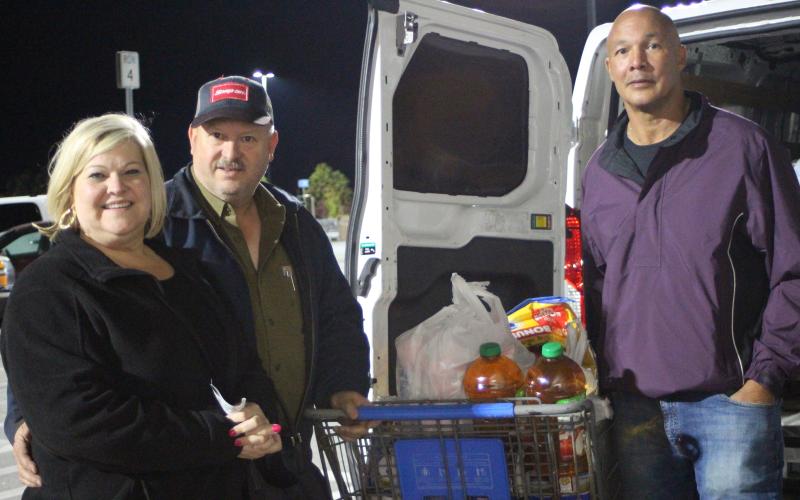 Megan Broome/The Clayton Tribune. Lori Hunter, left, Jeff Hunter of Hunter Electric with Food Bank Manager James Brim.