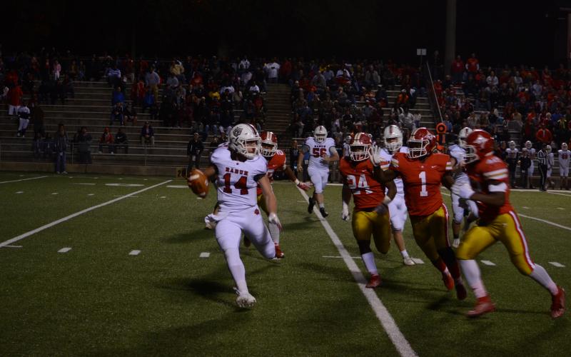 Rabun County quarterback Gunner Stockton (14) tries to avoid oncoming Thomasville defenders Friday night.